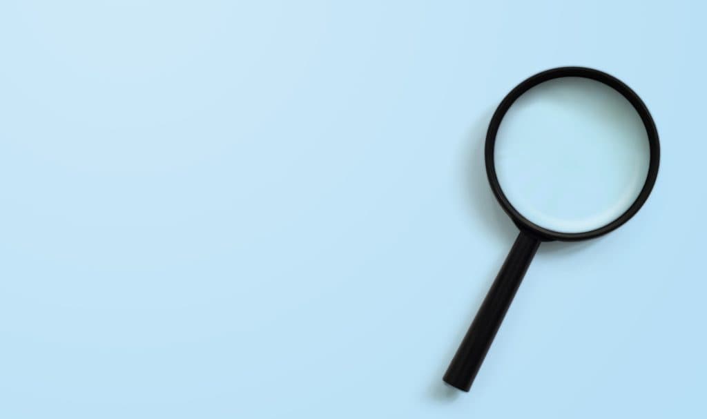 Black magnifying glass on a light blue background